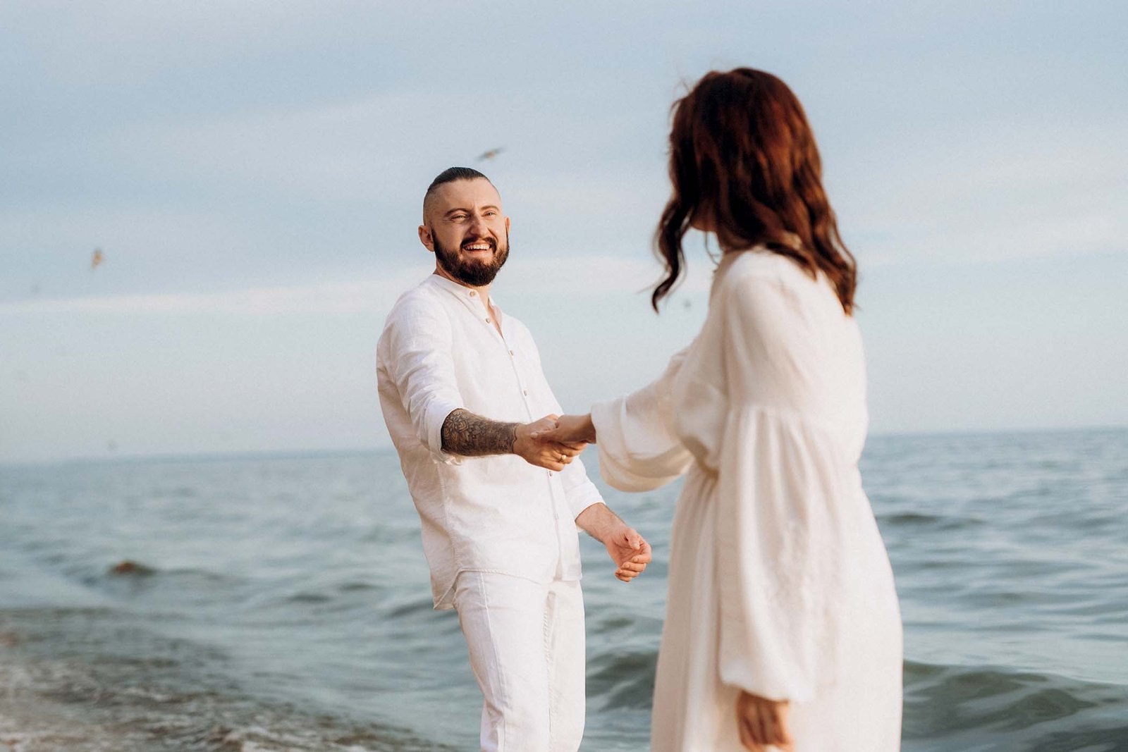 a-guy-with-a-girl-in-white-clothes-on-the-seashore-VPZ57AE.jpg